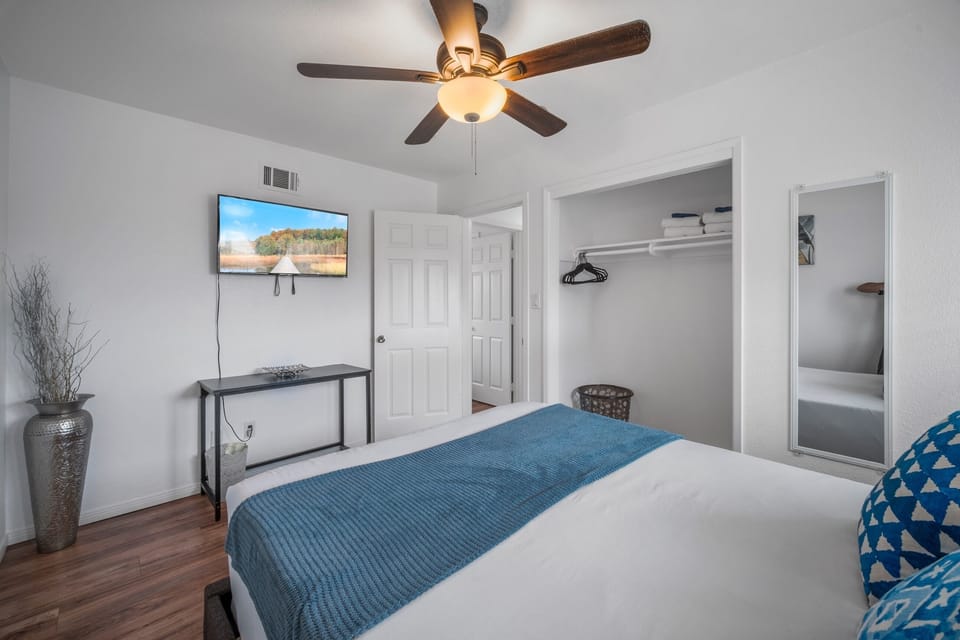 Elegant blue accents, TV, and serene atmosphere make it a cozy retreat.