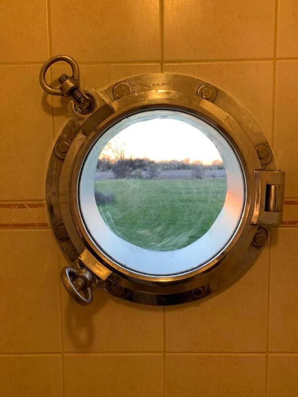 Authentic porthole in the shower with views of the property