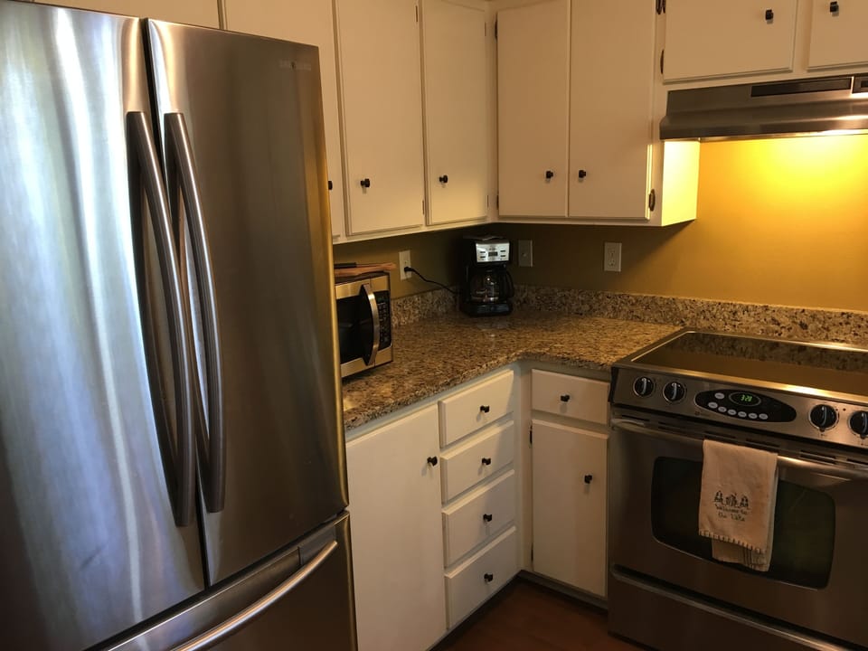 Kitchen with large fridge, microwave, oven/range, dishwasher, coffee maker