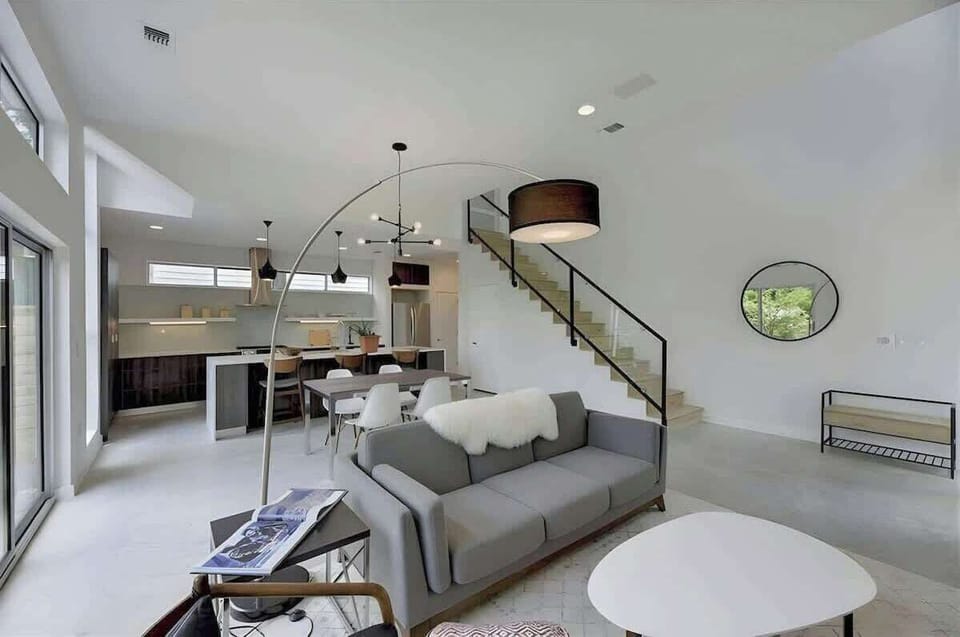 Open Living Dining Kitchen to floor to ceiling glass looking out at back yard