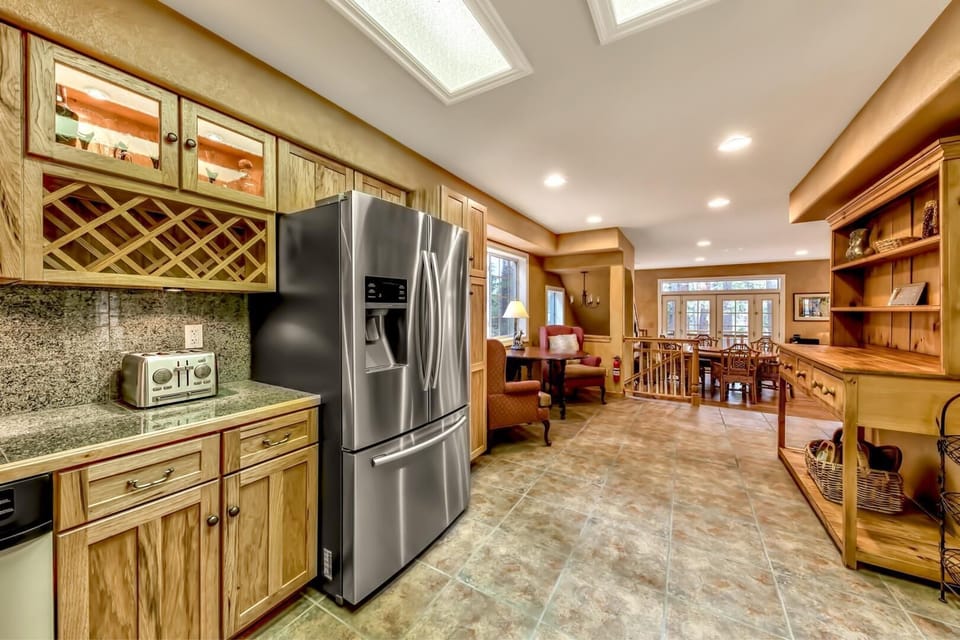 Your spacious gourmet kitchen features granite counters, stainless appliances, and skylights that bathe the warm wood cabinetry in natural light.