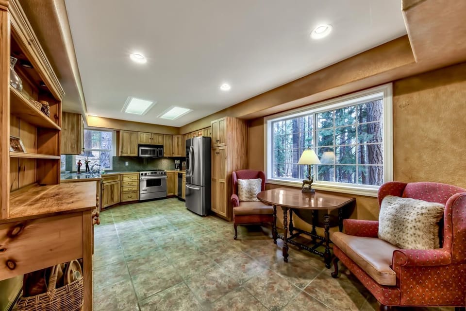Warm wood cabinets and mountain forest views create your perfect kitchen retreat, with cozy dining nook for morning coffee.