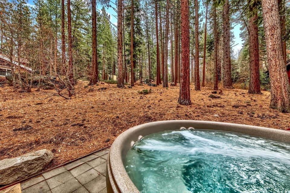 Soak your worries away in this private hot tub surrounded by towering pines and forest serenity.