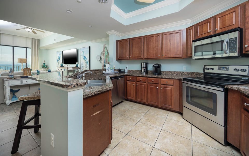 This kitchen features stainless appliances, granite countertops, a Keurig and coffee maker, and a beach front view