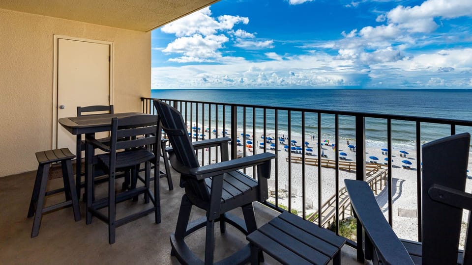 Relax on the balcony with a table and chairs, enjoying the serene beach view and gentle waves below
