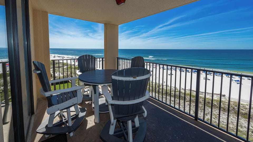 Enjoy a relaxing moment on the balcony with a round table and chairs, overlooking the beach and azure waters