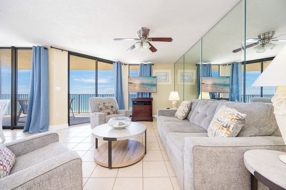 Soft couches invite you to unwind in the living room while coastal breezes drift through sliding doors to your balcony