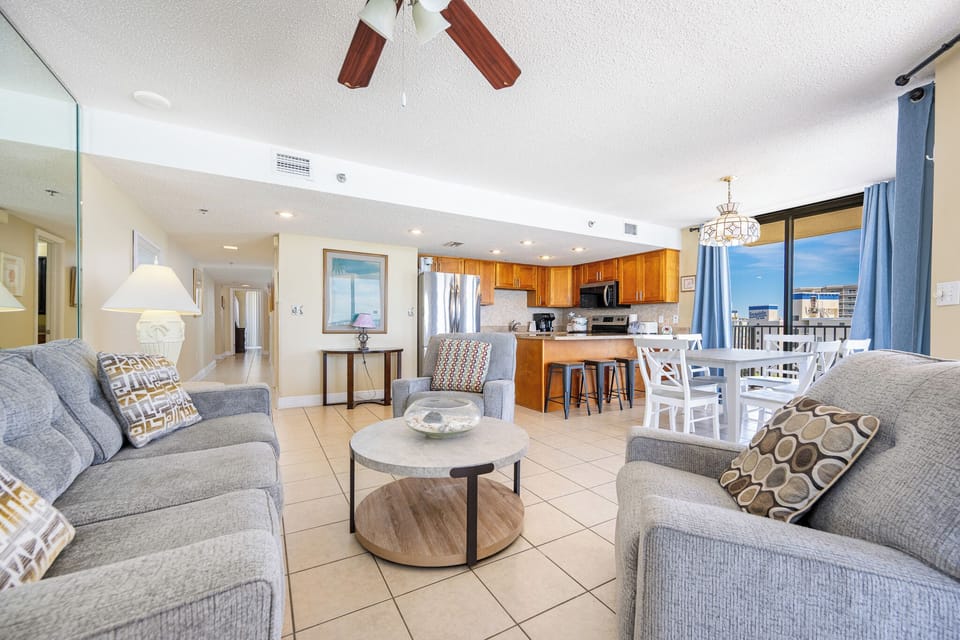 Sink into cozy cushions in the living room while hearing distant laughter from the pool below your balcony