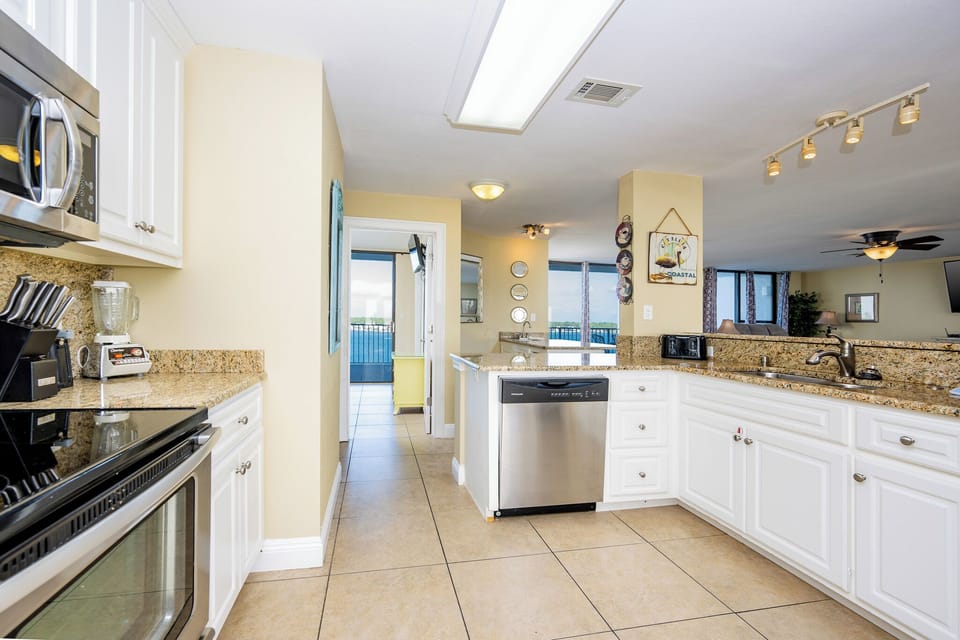 This kitchen features views on both sides, granite countertops, stainless appliances, and an open floor plan