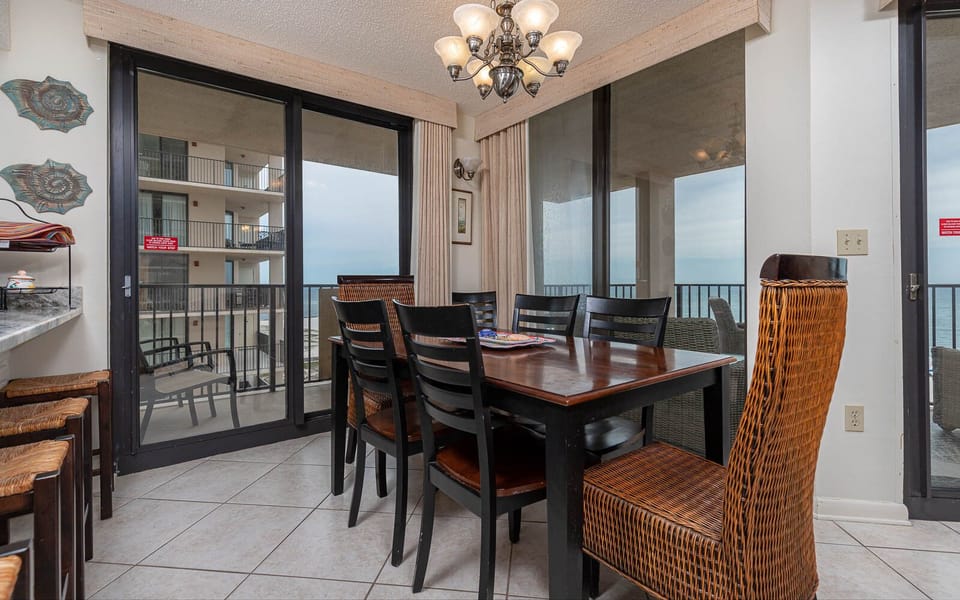 Dine with a view in this inviting space featuring a large table and sliding doors that open to the fresh gulf air