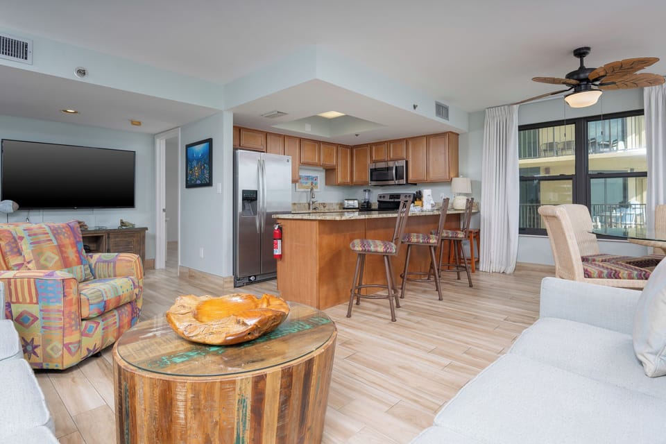 Inviting living area featuring colorful seating, a queen sofa-sleeper, modern kitchen with stainless appliances, and a cozy vibe