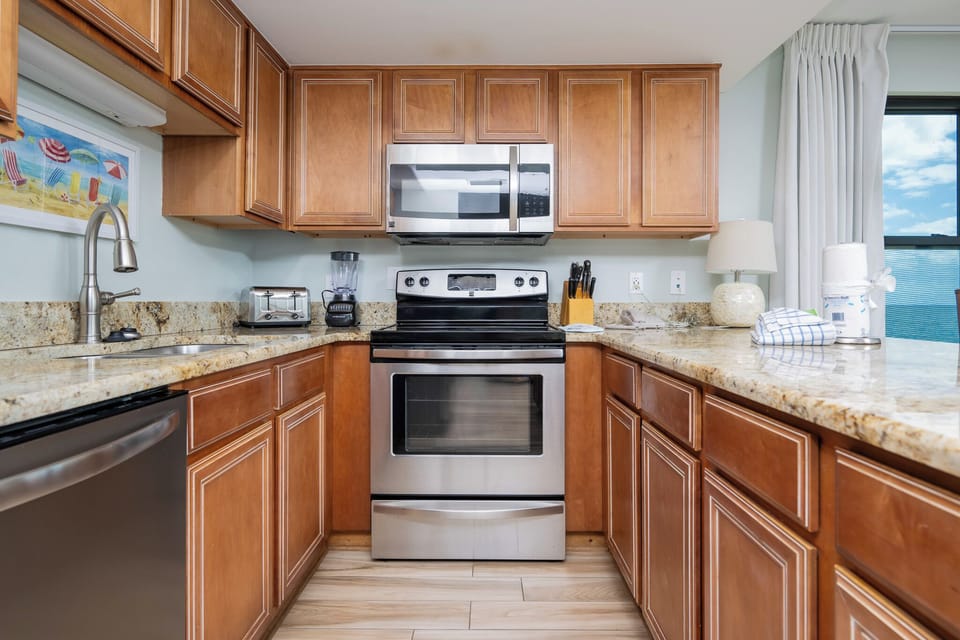 Modern kitchen featuring stainless appliances, granite countertops, and a lovely view through the window