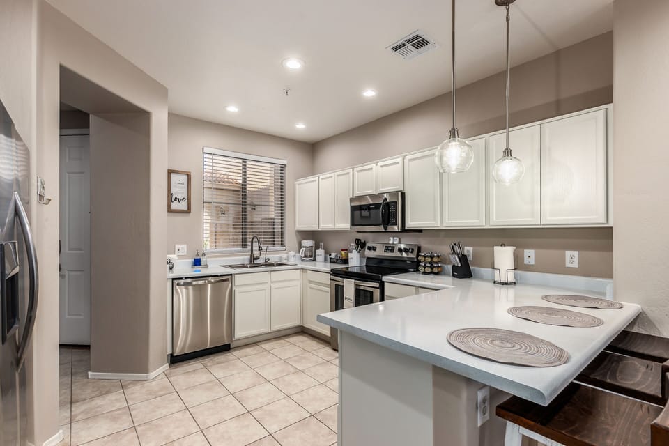 Fully stocked kitchen with bar seating and dining seating. 