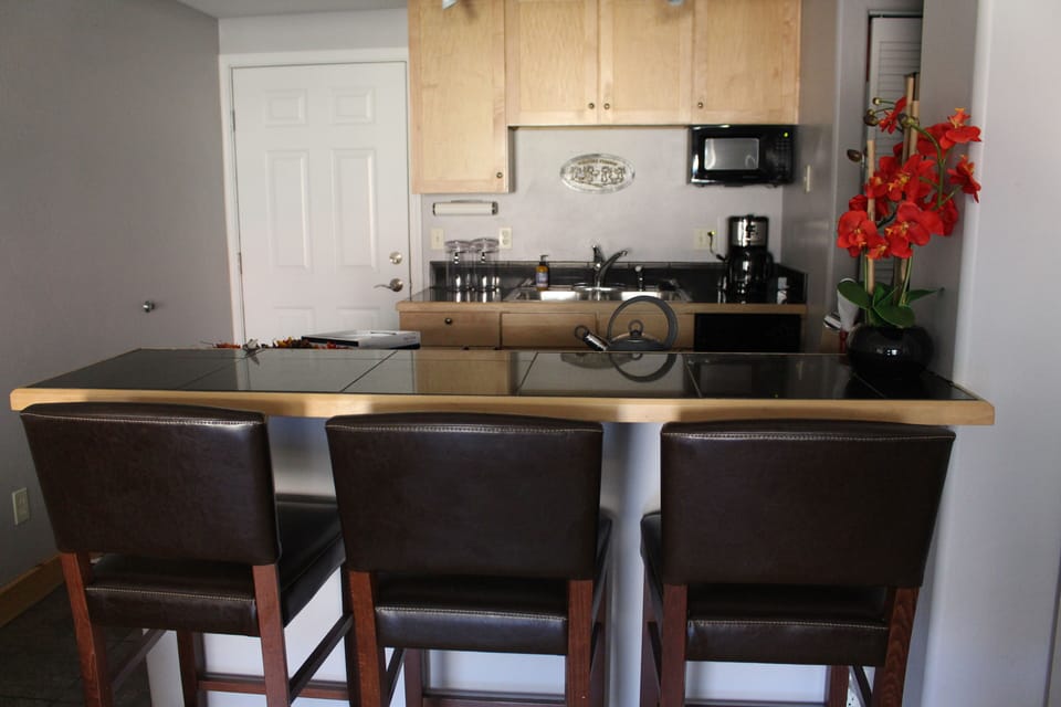 Granite tiled counter top with leather high back chairs make for perfect dining