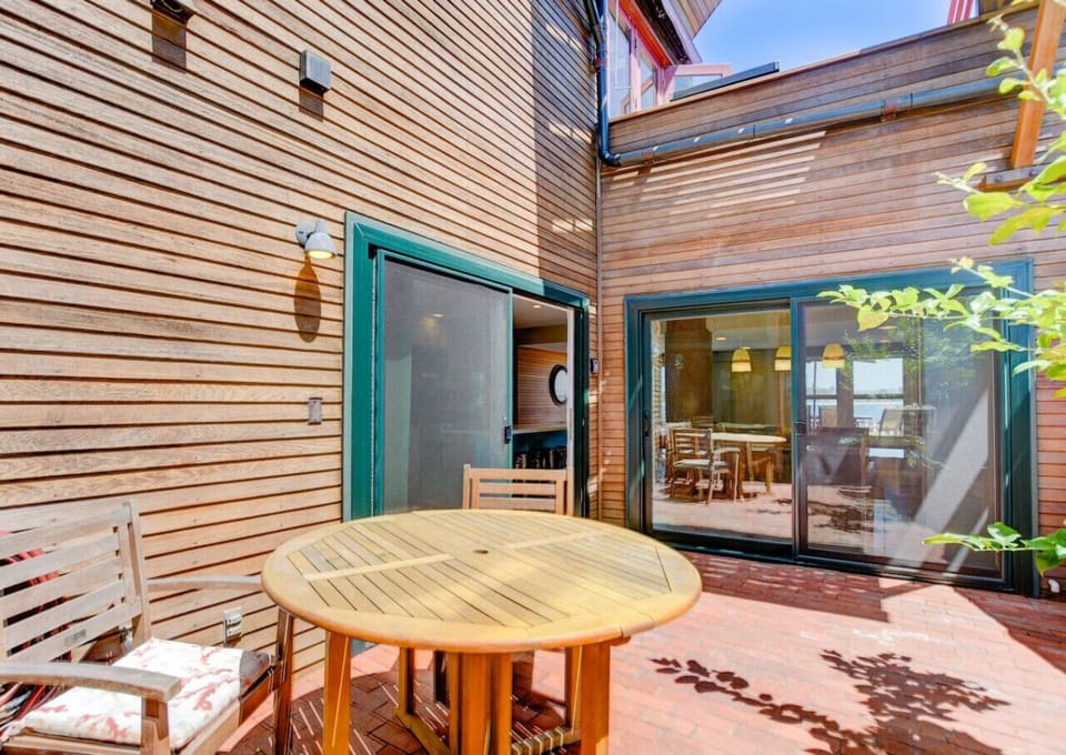Spacious, fully enclosed wooden deck with dining seating, offering a secluded spot to relax outdoors.