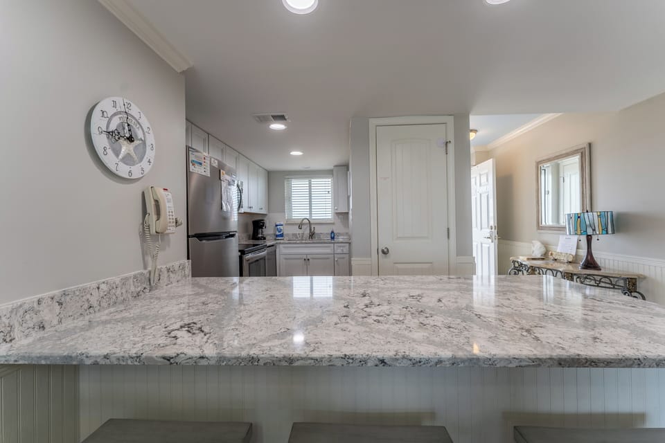 Lovely quartz bar for 3.
Stainless appliances w/ dishwasher. 