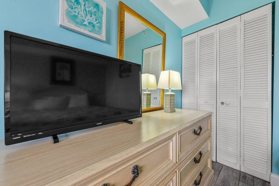 The 1st bedroom has a king-size bed, TV, and dresser for a comfortable stay!
