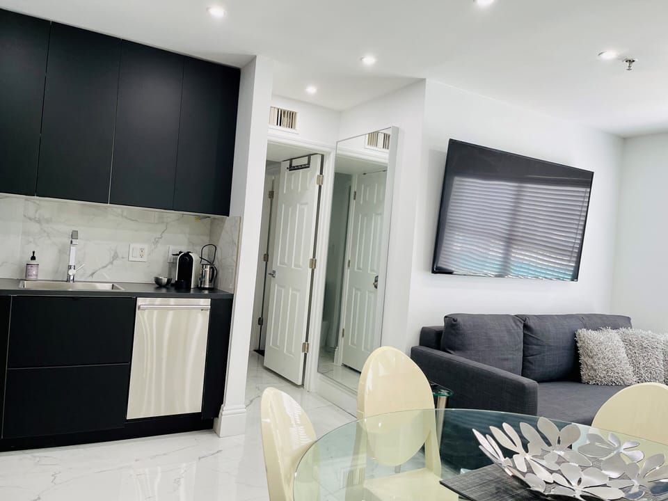 Stylish living and dining area with cozy sofa group and 70-inch Smart TV.