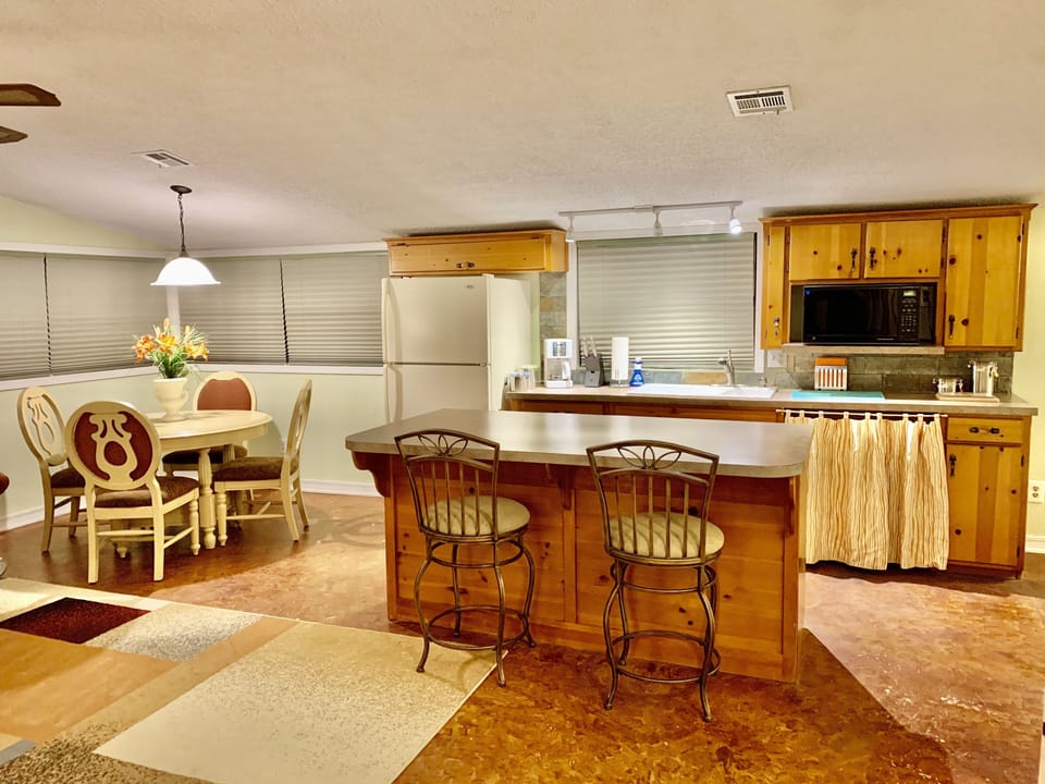 Kitchen with bar seating for 2 and dining area with seating for 4. 