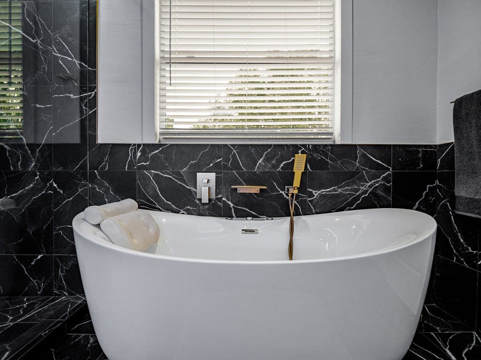 Jetted jacuzzi soaking tub with a waterfall faucet. 