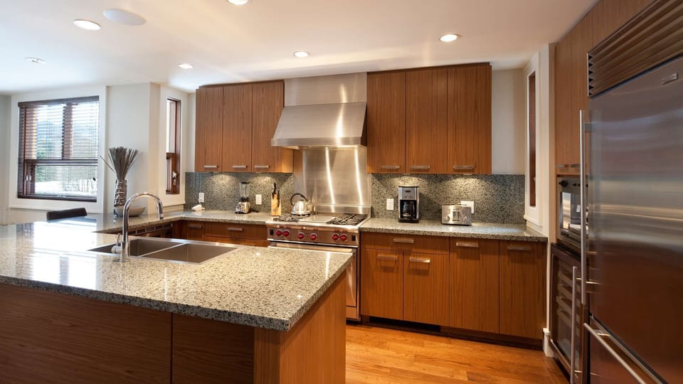 - Gourmet kitchen with sleek granite countertops and high-end stainless appliances  
- Spacious island perfect for breakfast prep or après-ski entertaining  
- Warm wood cabinetry adds elegance to your mountain escape home  