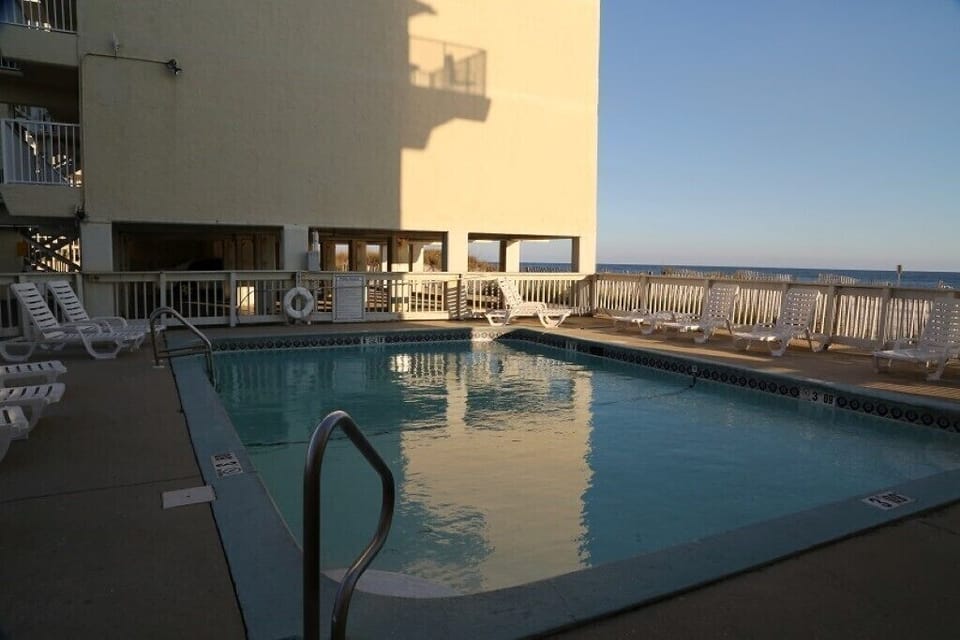 Condo complex pool that overlooks beach 