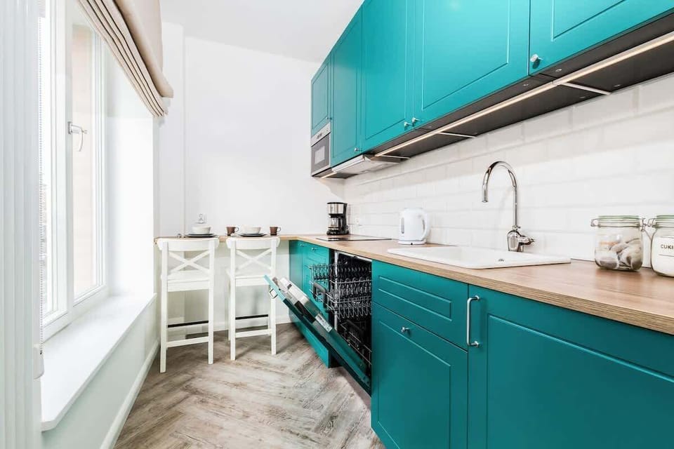 Kitchen with fridge, dishwasher, kettle, stove, sink, coffee maker, microwave, cupboards and dining area