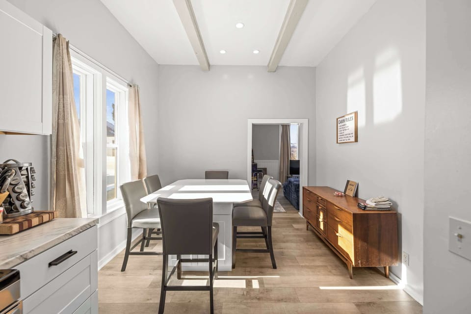 【Dining Room】 Original exposed beams overhead — the sideboard behind you is stocked for the group.