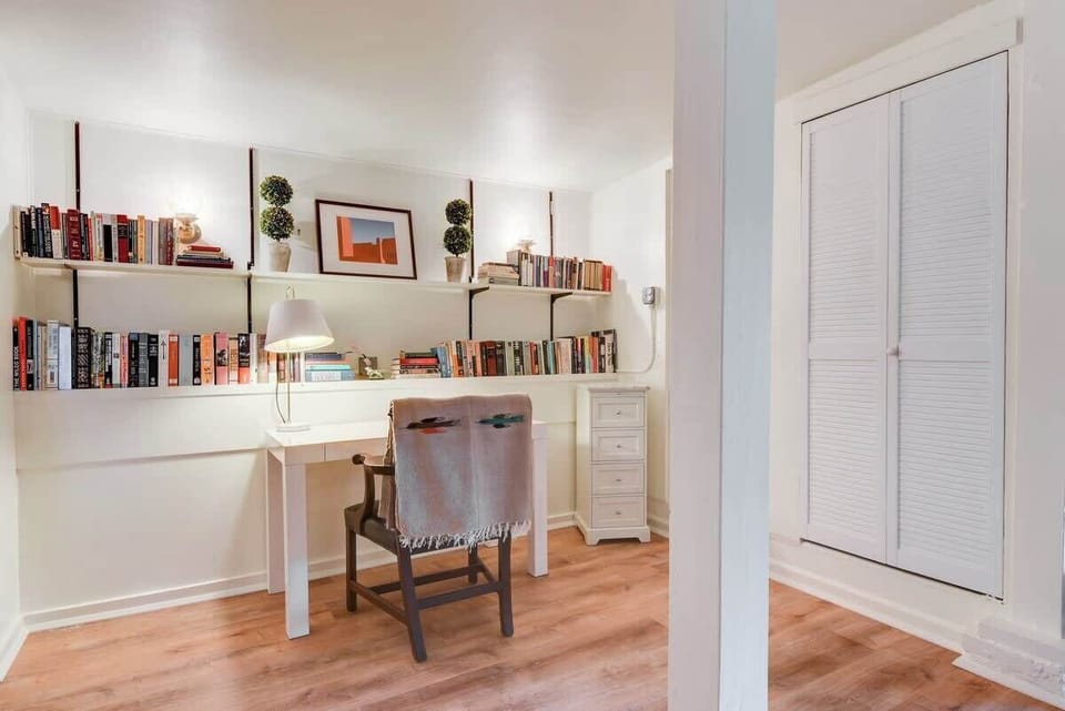 Quiet workspace with a desk and bookshelves, perfect for reading, studying, or catching up on work.