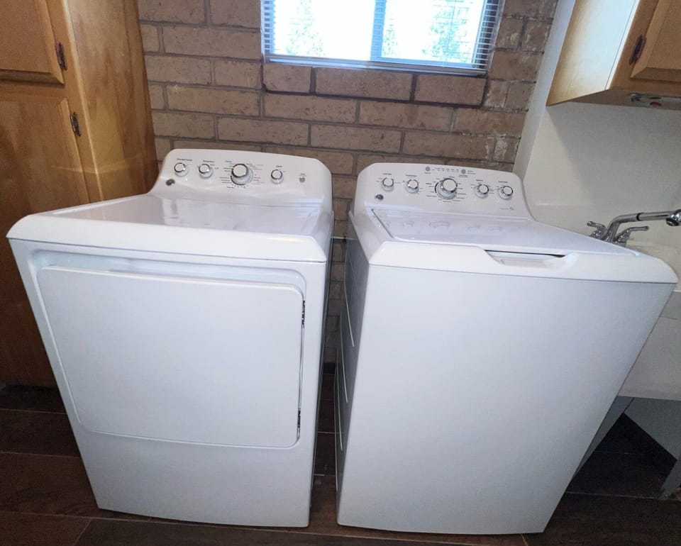 Laundry area with a washer and dryer under a window.