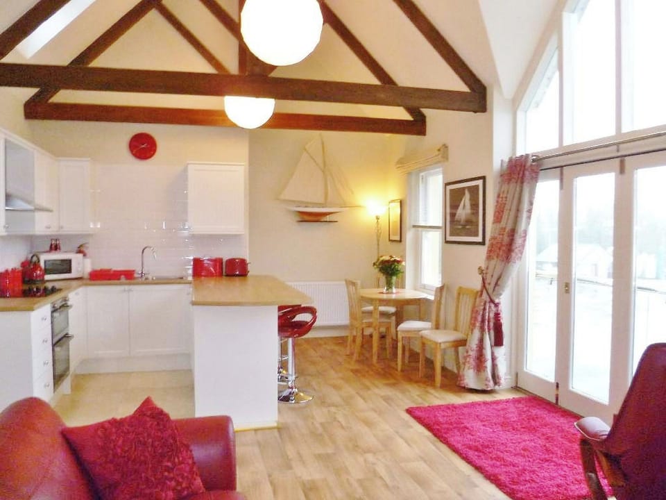 The main open plan living area with a striking feature window with Juliet balcony | Watch House, Fowey