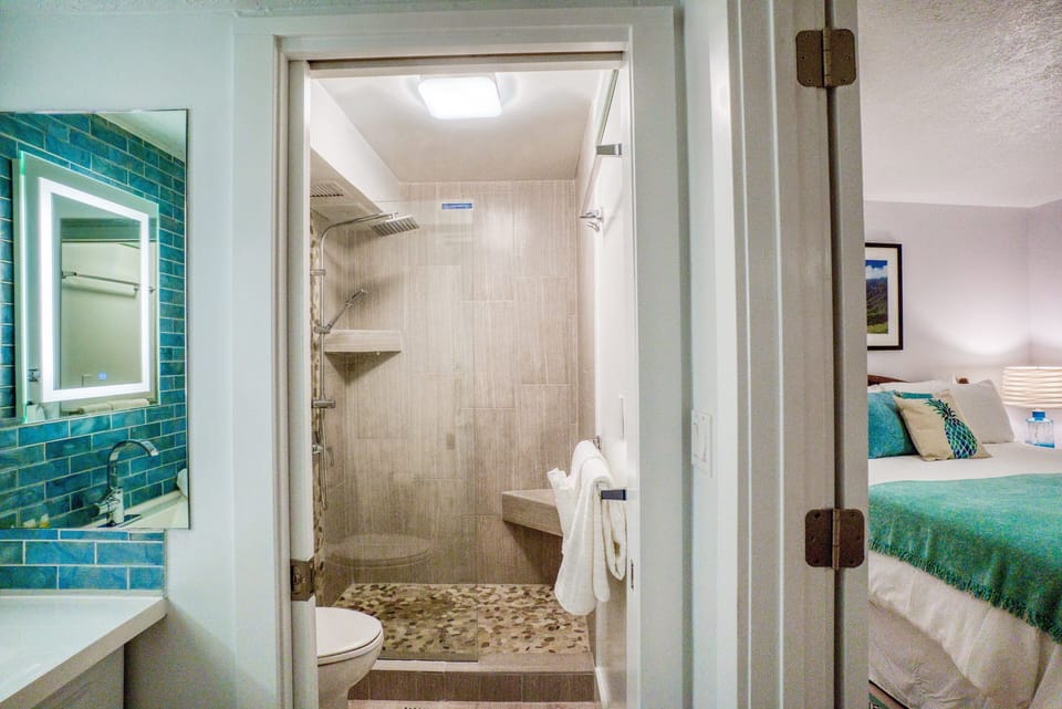 New designer tile rain shower with pebble floor has spa vibes.