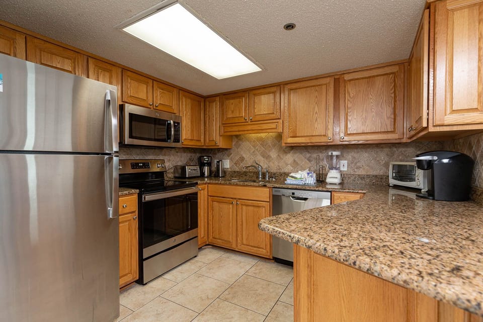 Cook meals with ease in this spacious kitchen featuring stainless appliances and wooden cabinetry