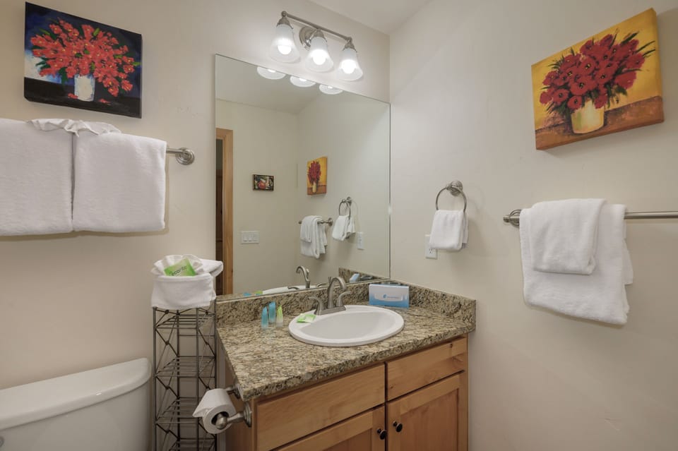 Step into your private bathroom featuring granite counters, warm wood cabinetry, and fluffy towels awaiting your arrival.