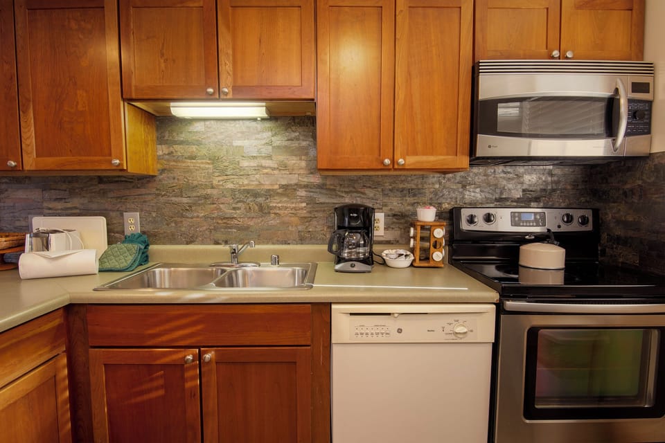 Your fully equipped kitchen features granite countertops, stainless appliances, and warm wood cabinetry—perfect for preparing memorable meals during your stay.