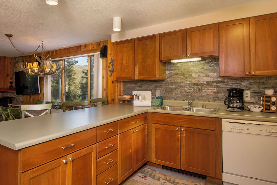 Your fully equipped kitchen features warm wood cabinetry, stone backsplash, and everything needed for memorable meals.
