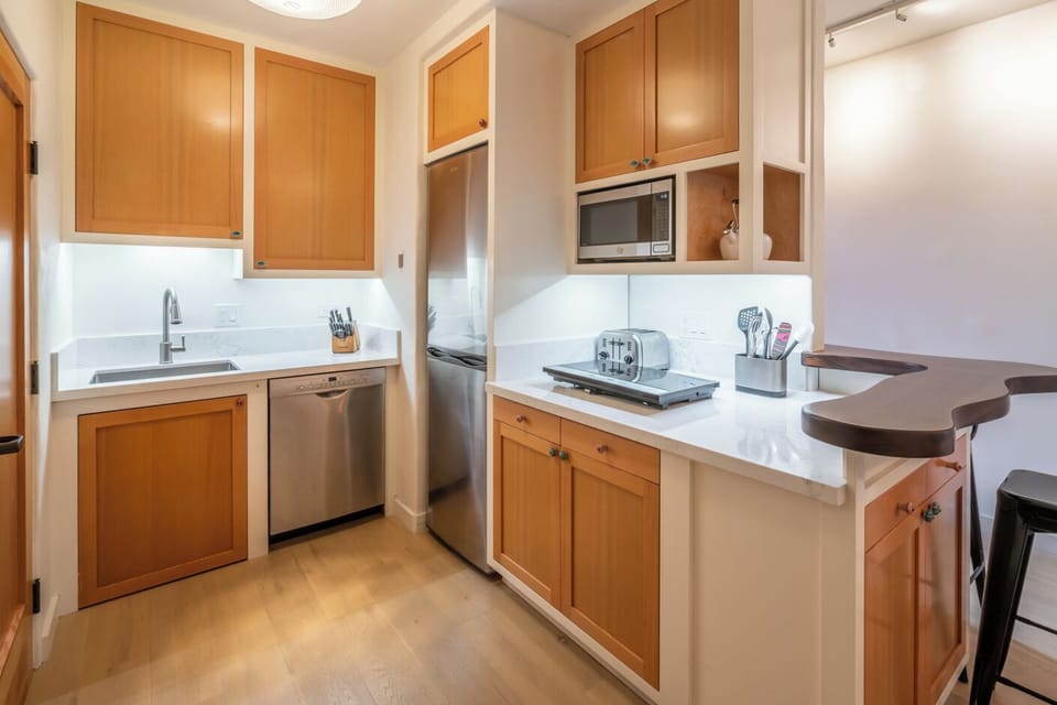 Kitchenette with efficiency cooktop, fridge, and dishwasher