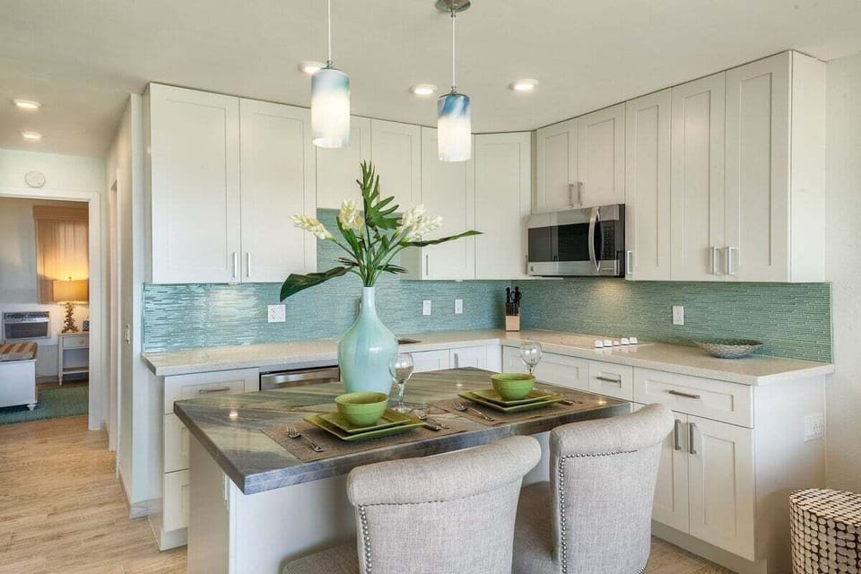 Fully equipped kitchen featuring stainless steel appliances and chic coastal design