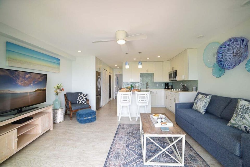 Bright and airy space featuring a large TV, dining area, and fully equipped kitchen