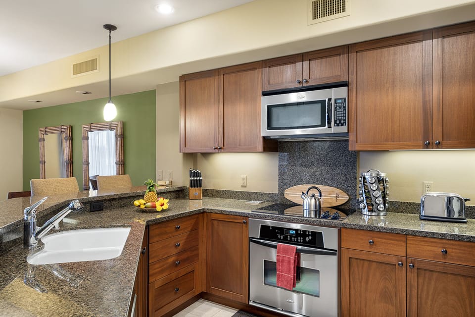 Kitchen area with in-counter sink, oven range, and microwave.