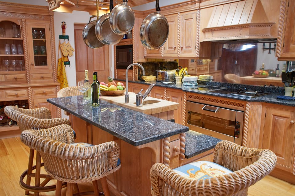A full equipped kitchen with centre social bar and access to pantry in back.