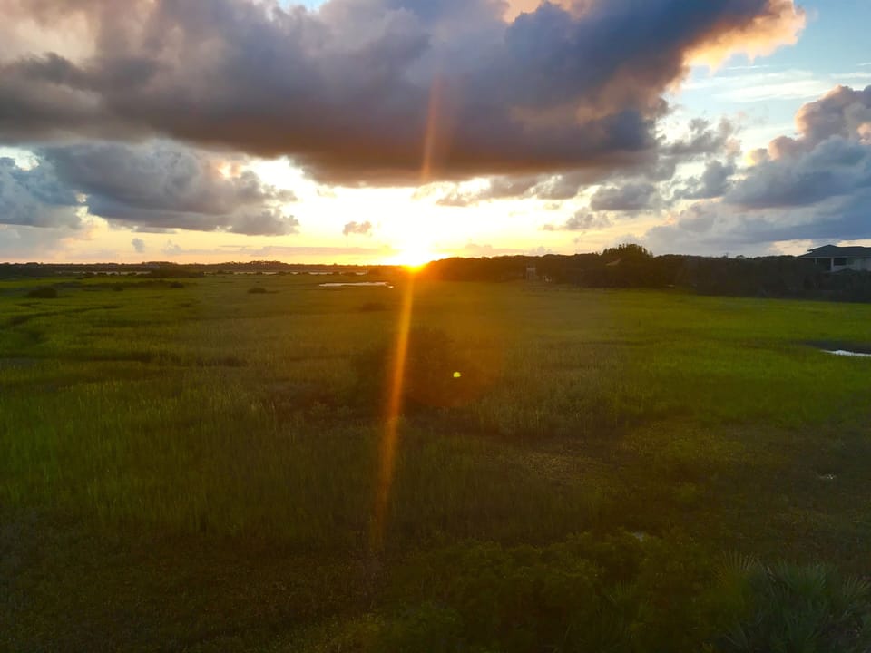 Sunset view off screened porch/back of house.