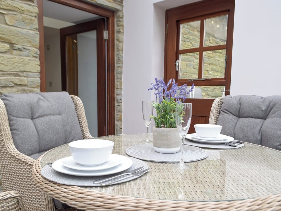 Sun room/dining area with patio doors leading to garden | Snowdrop Cottage - Penfeidr Cottages, Glanrhyd, near Newport