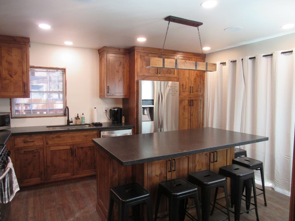 Kitchen with center island for dining and sliding glass doors to back patio