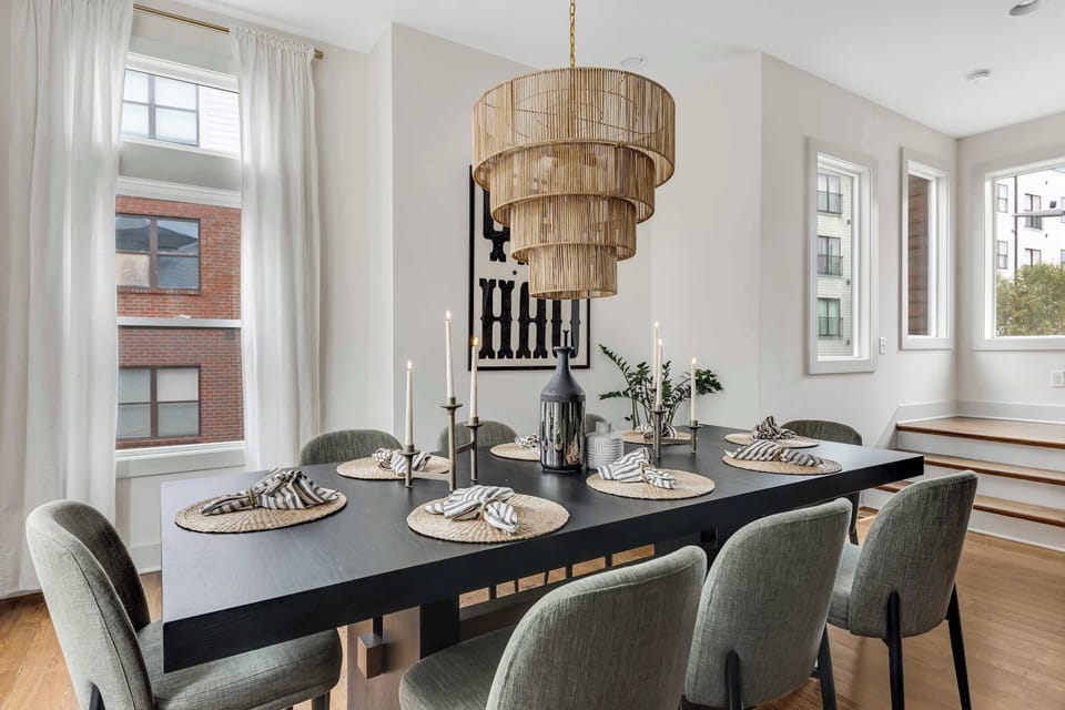Elegant dining table with modern chandelier and seating.