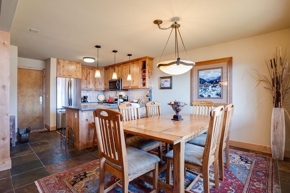 Gather around this warm wood dining table where mountain views frame your meals and rustic charm meets modern comfort.