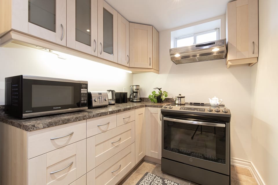 Kitchen with Tea Kettle, Coffee Maker, Oven & Stove, Fridge, Pots and Pans. 