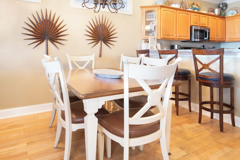Gather around your spacious dining table for memorable meals, with tropical palm art setting the perfect coastal vibe for your getaway.