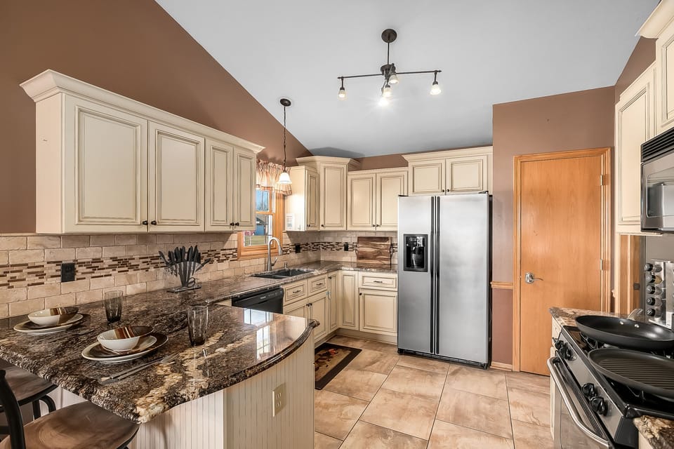 Kitchen has beautiful cabinetry and stone countertops