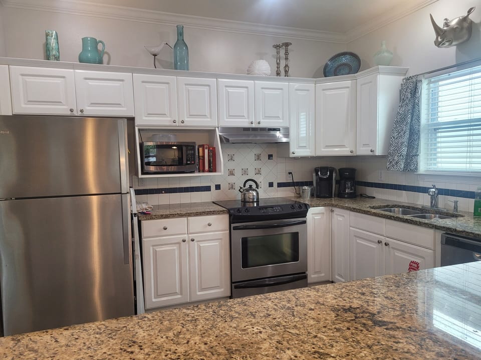Remodeled kitchen w/ stainless steel appliances, bar & granite counters.